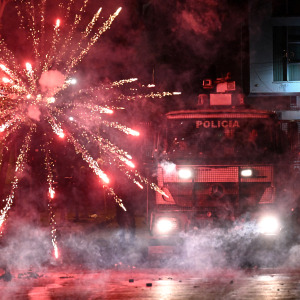 Fireworks explode next to a police truck during an anti-government demonstration.