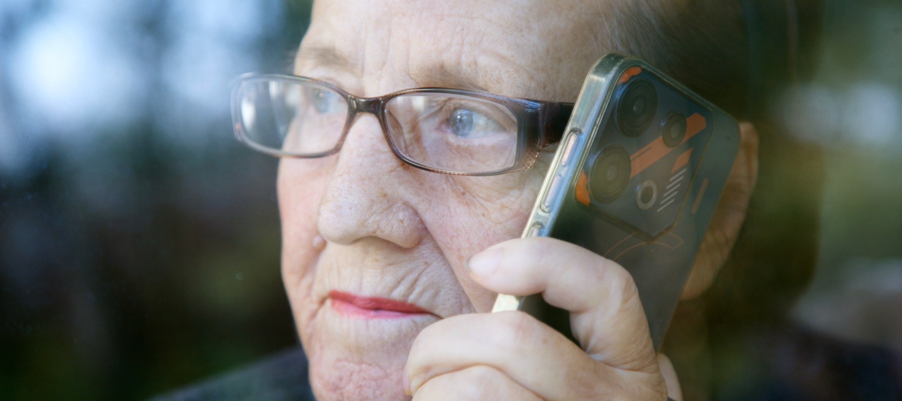 An old woman looking concerned while holding her phone