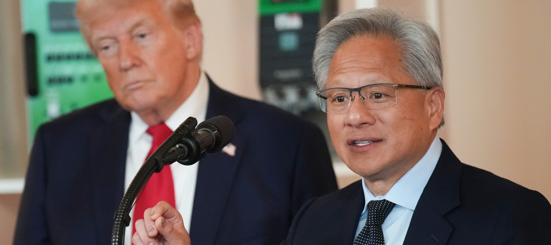 Trump listens as Nvidia CEO Jensen Huang speaks in the Cross Hall of the White House.