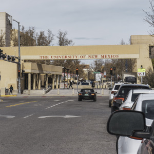 Image of the exterior of New Mexico University Hospital. Also pictured is some ongoing traffic.