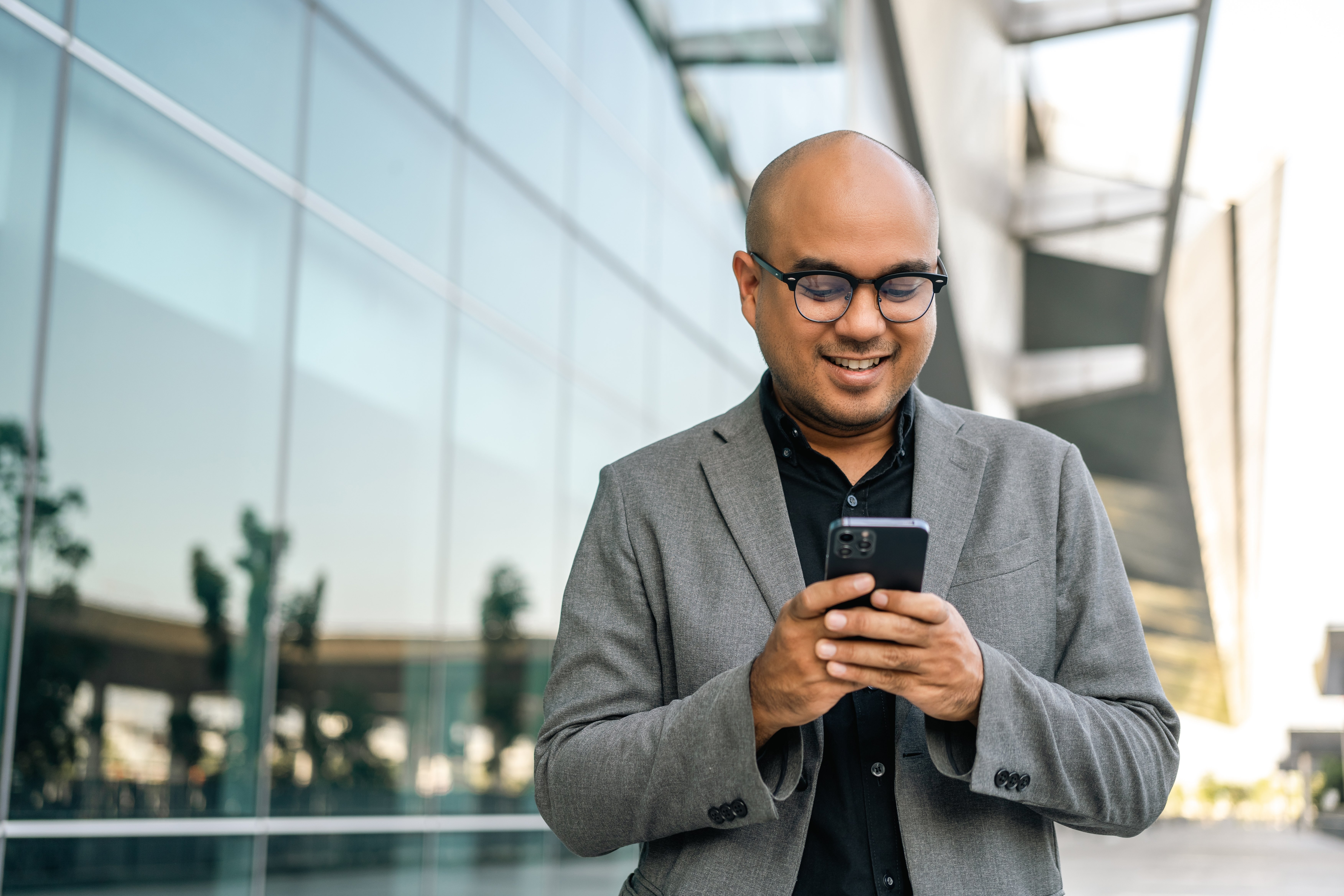 Senior manager business man in suit with cell phone at the buildings downtown. Confident man using smartphone looking towards their goals for success. Executive business man