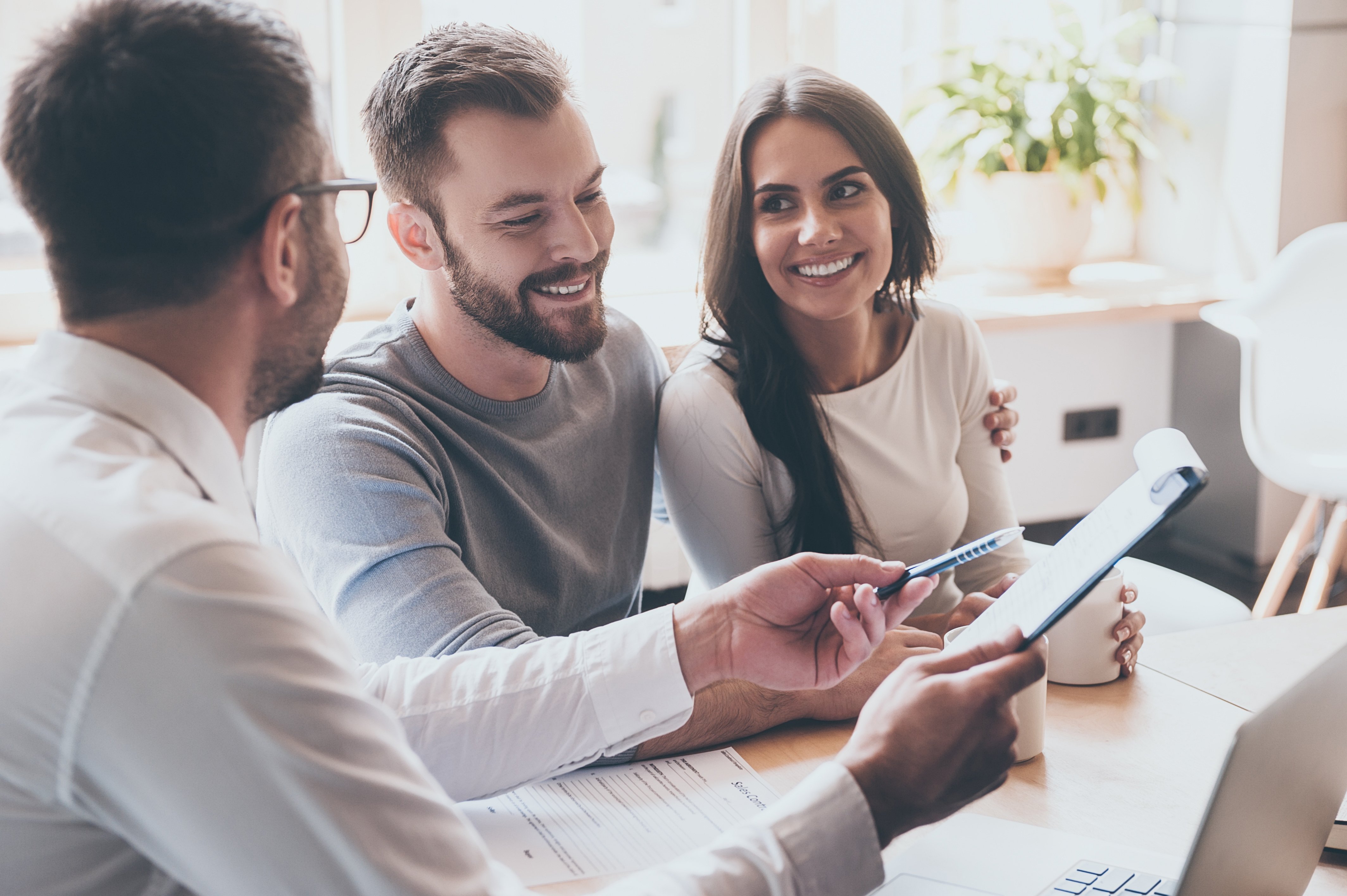 A couple with their estate agent signing on a new property