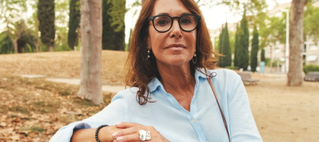 Woman sitting at park bench outside.